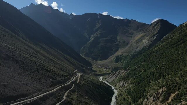 Aerial Drone Footage of a road and a river flowing beside the road in the Himalayas in Niti valley.
