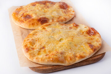 Homemade Ossetian pies on a wooden board on a white background. Homemade food concept.