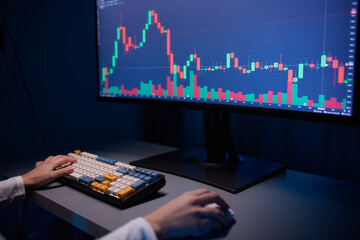 Finger to the graph on the monitor. Team of stockbrokers are having a conversation in a office with multiple display screens.