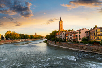 The bell tower of the 13th century Basilica di Santa Anastasia can be seen at sunset from the Ponte Pietra bridge in the medieval old town of Verona, Italy.