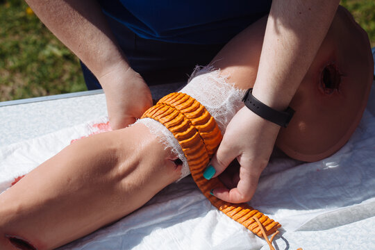Medic applies a tourniquet to arm. Medical training