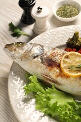 Delicious baked fish and vegetables on wooden table