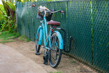 blue cruiser bike with flip flops leaning against a fence in Kauai, Hawaii