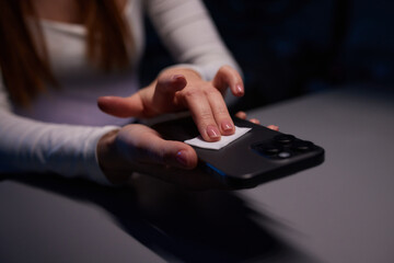 Hand female cleaning her smartphone with microfiber cloth