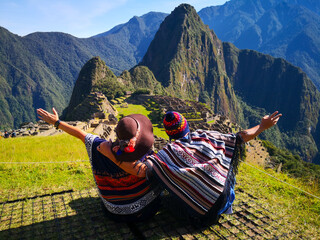 Couple admiring Machu Picchu mountain, Sacred Valley, and the surrounding peaks from above