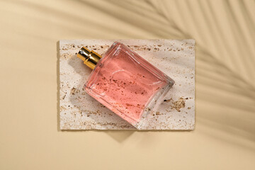 Luxury women's perfume in bottle on beige background, top view