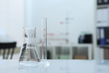 Laboratory analysis. Flask and test tube on table indoors, space for text