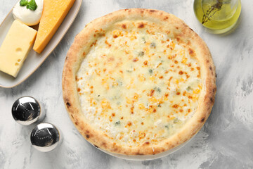 Delicious cheese pizza, oil and different kinds of cheese on light grey textured table, flat lay