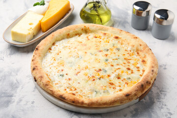 Delicious cheese pizza, oil and different kinds of cheese on light grey textured table
