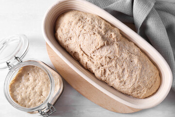 Fresh sourdough starter and dough on light table, top view