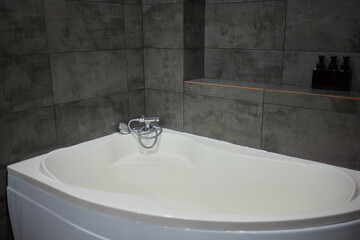 White metal whirlpool bath without water in apartment bathroom.