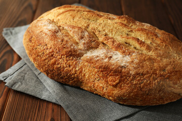 Freshly baked sourdough bread on wooden table, closeup