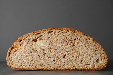 Piece of freshly baked sourdough bread on grey table, closeup