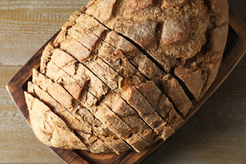 Freshly baked cut sourdough bread on wooden table