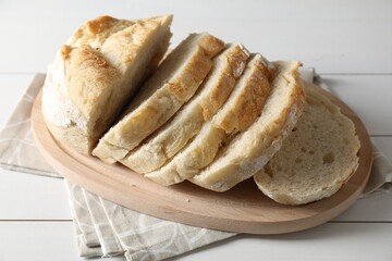 Freshly baked cut sourdough bread on white wooden table