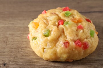 Raw dough with candied fruits on wooden table, closeup