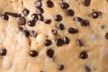 Raw dough with chocolate chips as background, top view