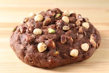 Raw chocolate dough with nuts on wooden table