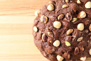 Raw chocolate dough with nuts on wooden table, top view. Space for text