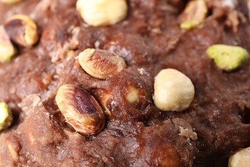 Raw chocolate dough with nuts as background, closeup