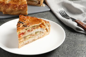 Piece of tasty homemade pie with filling served on grey table