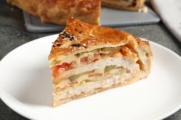 Piece of tasty homemade pie with filling served on grey table, closeup