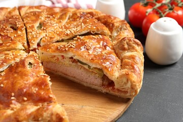 Cut delicious homemade pie on black table, closeup