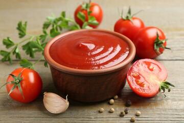 Tasty ketchup, fresh tomatoes, parsley and spices on wooden table