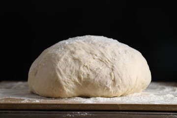 Raw homemade dough on wooden table, closeup