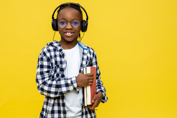 Cute dark-skinned boy with books in hands feeling positive