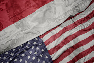 Obraz premium waving colorful flag of united states of america and national flag of indonesia on the dollar money background. finance concept.