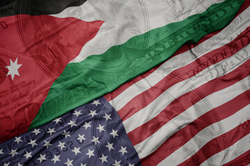 Obraz premium waving colorful flag of united states of america and national flag of jordan on the dollar money background. finance concept.