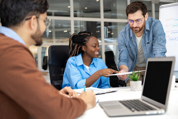 Group of coworkers with laptop having meeting in office
