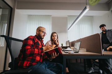 A group of young professionals collaboratively discuss a project in a well-lit, contemporary office...