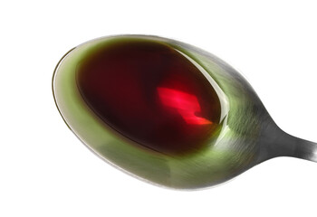 Pumpkin oil puddle in metal spoon isolated on white, top view, clipping path