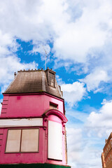 Pink building against sky with clouds
