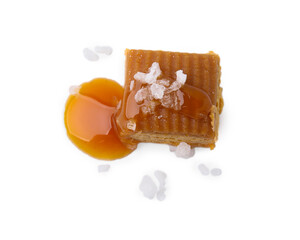 Yummy caramel candy and sea salt isolated on white, top view
