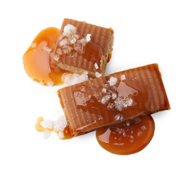 Yummy caramel candies and sea salt isolated on white, top view