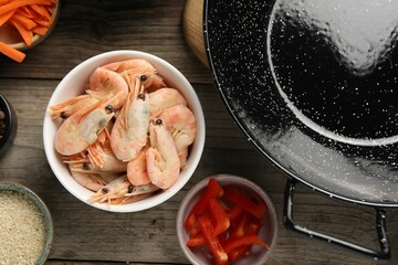 Flat lay composition with black wok and products on wooden table