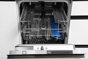 Built-in dishwasher with open door indoors. Home appliance