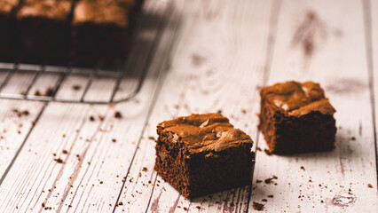 Chocolate chip brownies on a wooden background with crumbs around. Selective focus.