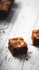 Chocolate chip brownies on a wooden background with crumbs around. Selective focus.