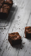 Chocolate chip brownies on a wooden background with crumbs around. Selective focus.