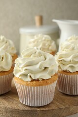 Obraz na płótnie Canvas Tasty vanilla cupcakes with cream on table, closeup
