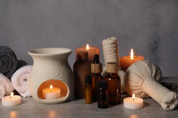Aromatherapy. Scented candles and spa products on gray textured table