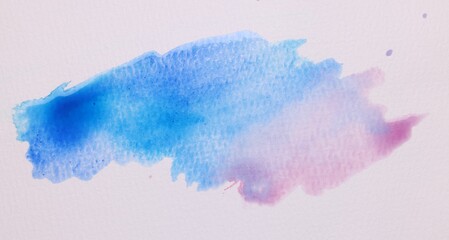 Blot of bright watercolor paints on white paper, top view