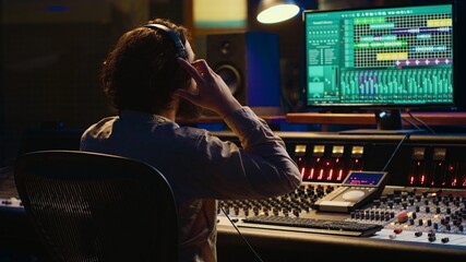 Sound designer working on track recording with audio professional software, operating technical...