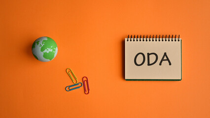 There is notebook with the word ODA. It is an abbreviation for Official Development Assistance as eye-catching image.