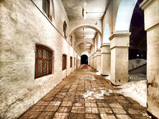 Old Ancient Colonnade Pathway at Night. Dimly lit corridor with arches and age-worn columns