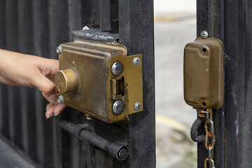 hand of a person opening the lock of a metal door, home security object, wallpaper